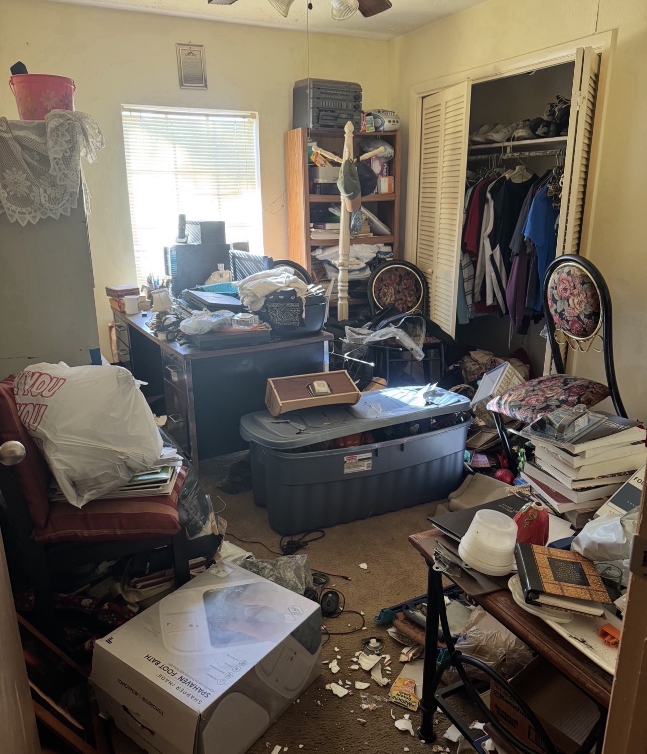 Cluttered bedroom full of furniture, boxes and belongings before a house cleanout in Houston