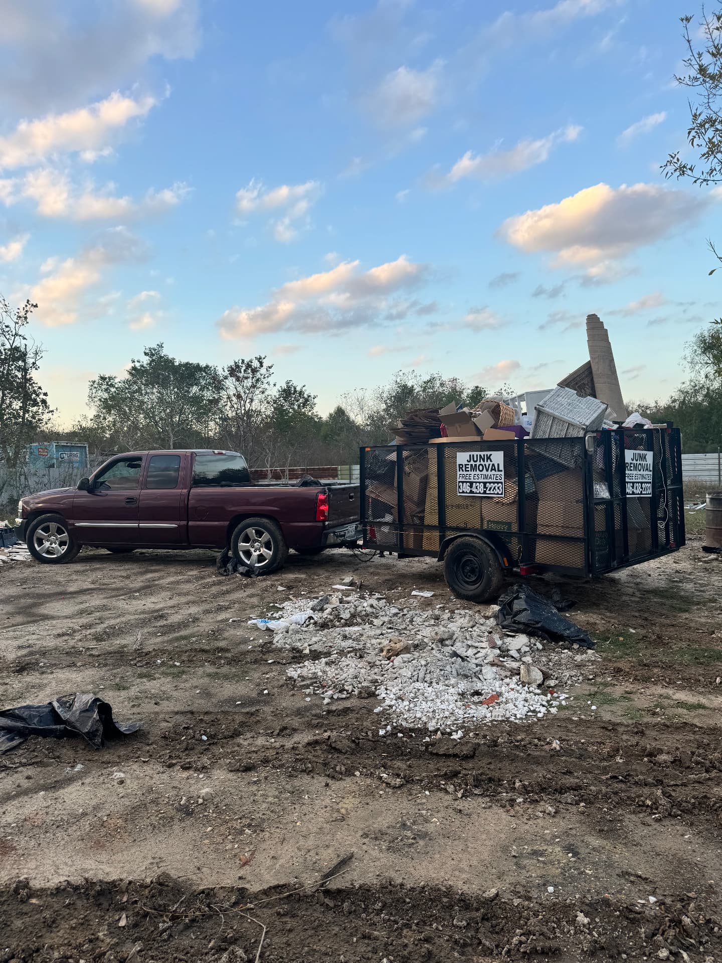Angels Junk Removal trailer loaded with furniture and household debris at a Houston area dump site