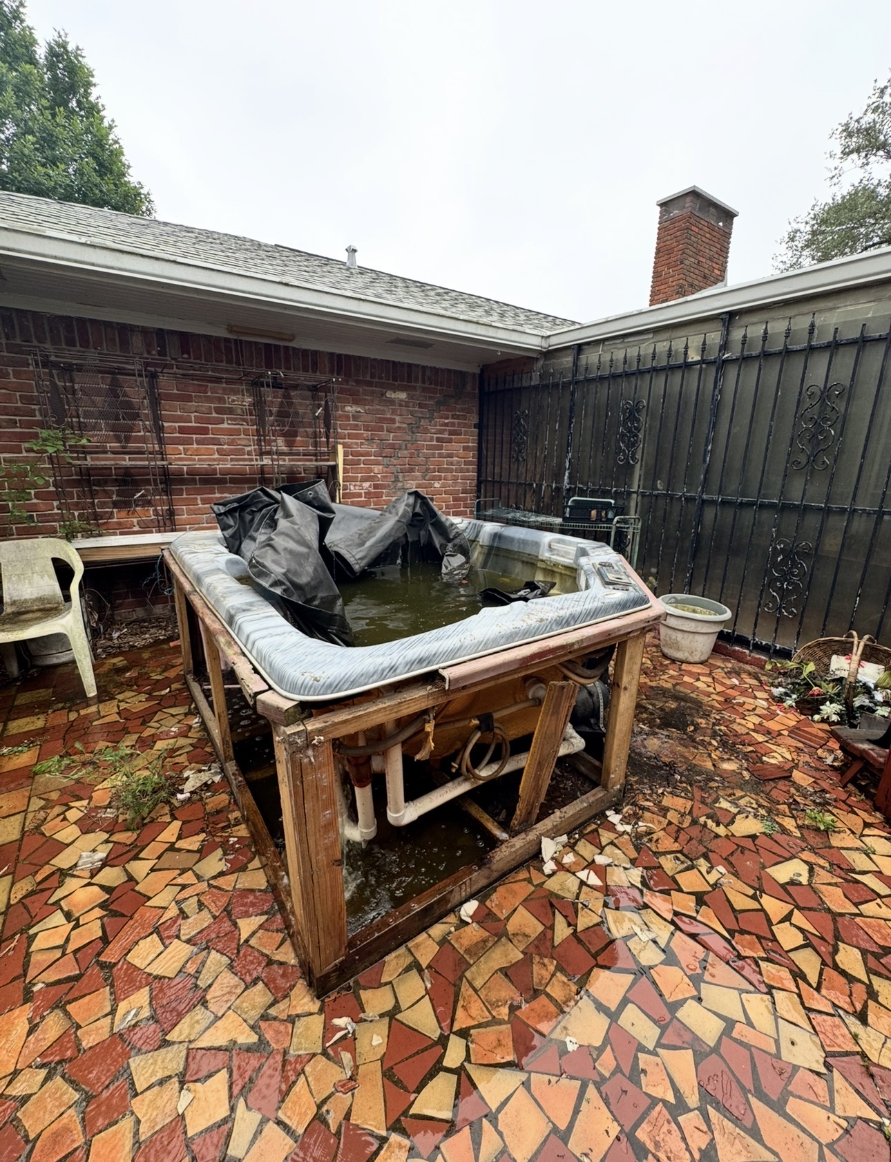 Old backyard hot tub on a wood frame before demolition and removal in the Houston area